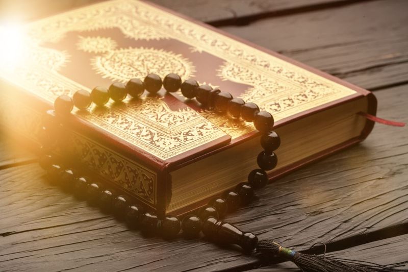 quran-and-prayer-beads-on-wooden-floor-1567597692834